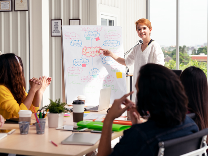 Woman at white board leading a staff discussion